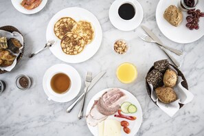 A breakfast setting with pancakes, croissants, and a variety of spreads on plates. - Kurhotel Skodsborg (Skodsborg)