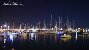 A marina at night with numerous boats docked, illuminated by artificial lights. - Diavin (Vibo Valentia)