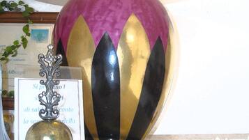 A decorative lamp with a unique design, placed on a table with a placard and brochures.