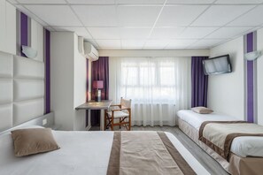 A hotel room with two beds, a desk, a chair, a TV, and a window with curtains. - Hotel Le Sablier Du Temps (Argentat-sur-Dordogne)