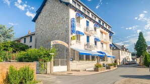 Un hotel con fachada de piedra, varios balcones y un cartel que indica que es un hotel.