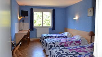 A room with two beds, a desk, a television, and a window with curtains.