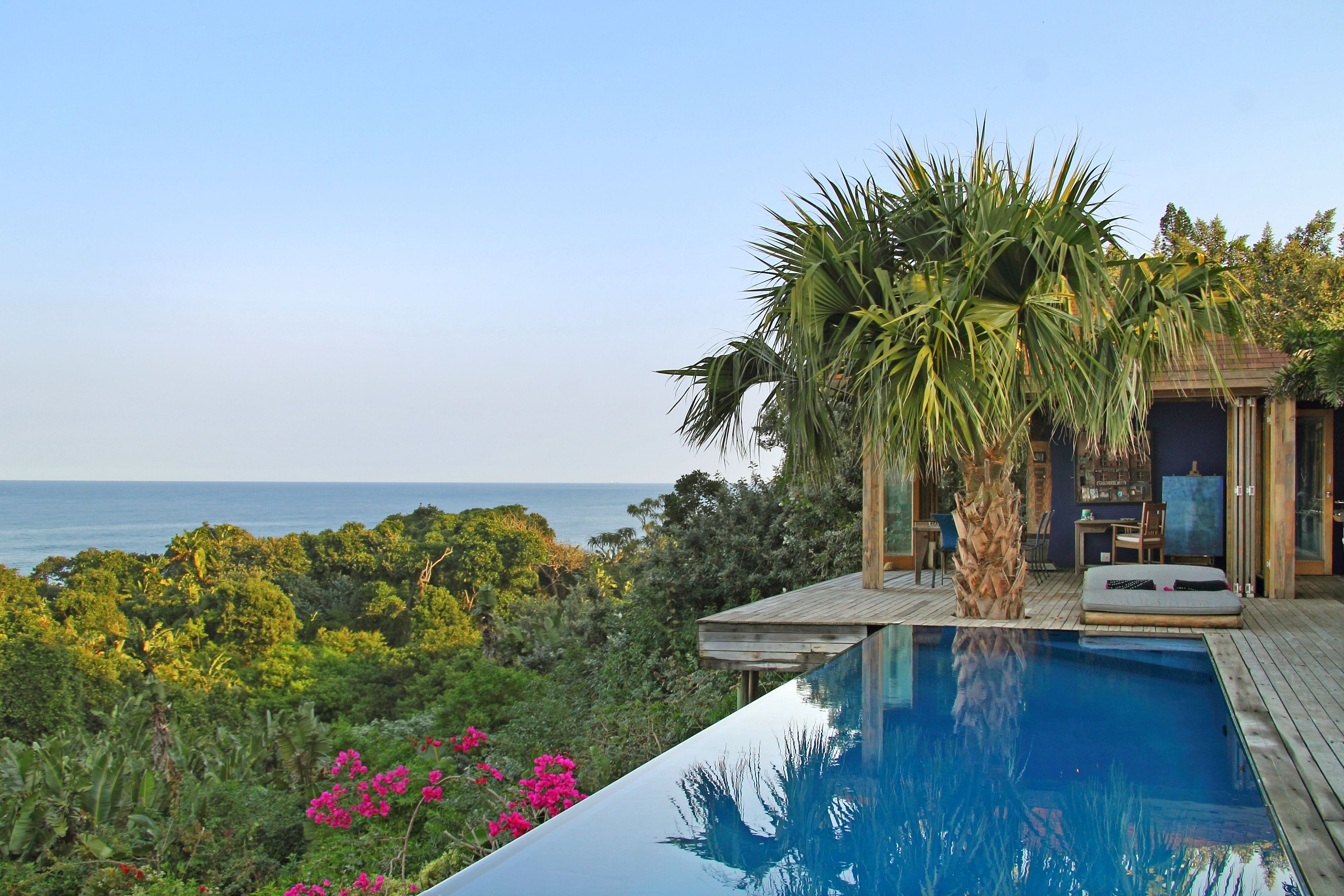 Outdoor pool, an infinity pool, pool umbrellas, sun loungers
