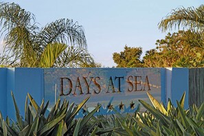 A sign with the text "DAYS AT SEA" surrounded by tropical plants. - Days At Sea Beach Lodge (Southbroom)