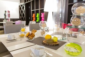 A breakfast setup with croissants, fruits, and a coffee cup on a table. - Hotel Revellata (Calvi)