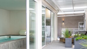 Un espace de vie extérieur moderne, doté d’une piscine, de portes-fenêtres coulissantes et d’un coin salon agrémenté de jardinières.