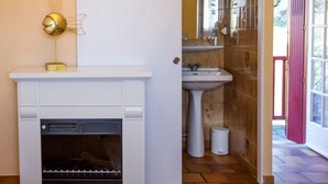 A bathroom with a white sink, a mirror, and a shower area. - L'Auberge Basque (Ozon)