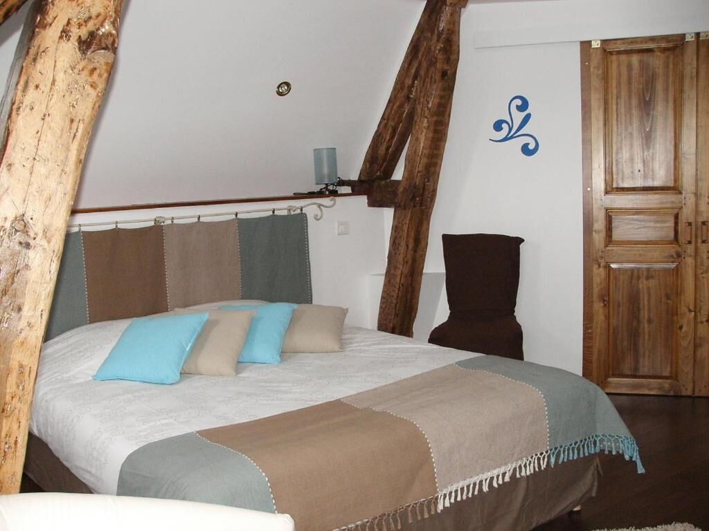 Un dormitorio con cama, puerta de madera y un detalle decorativo en la pared.