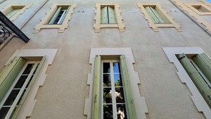 A building with multiple windows and a textured facade. -  Logis Hôtel des Thermes  (Lamalou-les-Bains)