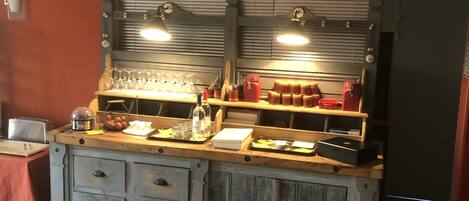 A kitchen with wooden cabinets, a countertop with various items, and a window with blinds.