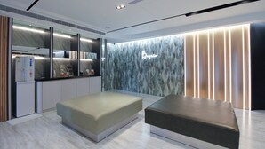 A modern hotel lobby with a reception desk, seating area, and a marble-patterned wall. - Hotel B (Taipei)