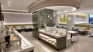 A modern dining area with a buffet, seating, and a view of the street. - Hotel B (Taipei)