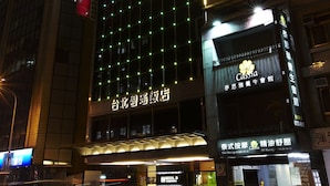 A hotel with a prominent sign, multiple floors, and a well-lit facade. - Hotel B (Taipei)