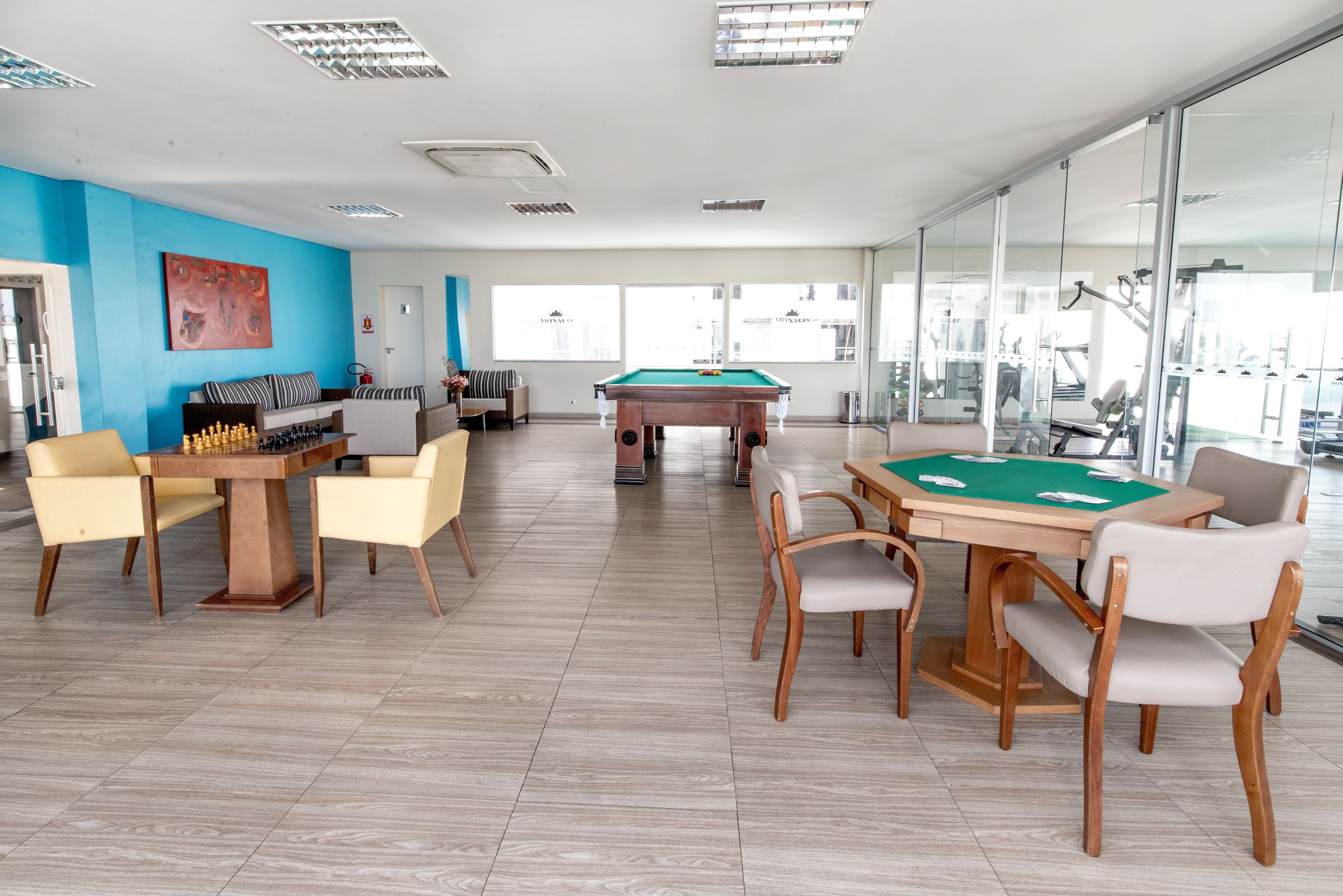 A spacious room with a pool table, a snooker table, and a chess table.