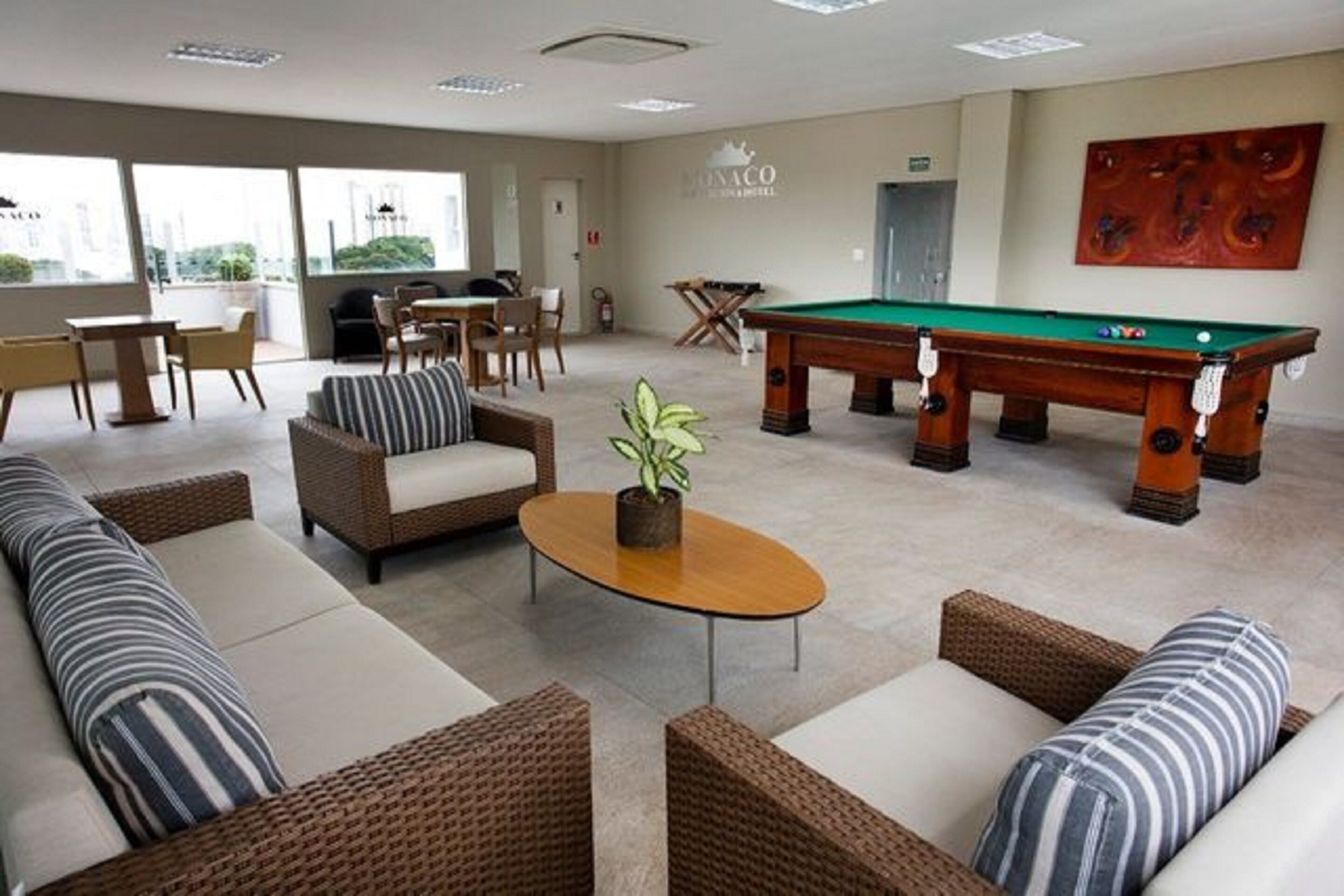 A lounge area with sofas, a pool table, and a dining table.