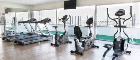 A gym with treadmills, stationary bikes, and elliptical machines.