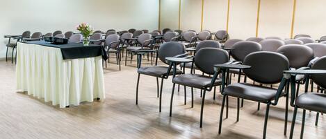 Una sala de conferencias con una larga mesa y sillas dispuestas para una reunión.