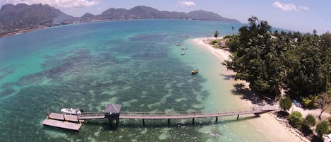 Vlak bij het strand, wit zand, ligstoelen aan het strand, parasols