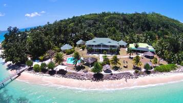 Una playa cerca, arena blanca, sillas reclinables de playa, sombrillas