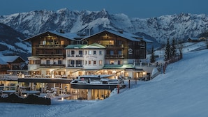 A multi-story hotel with a ski resort in the background.