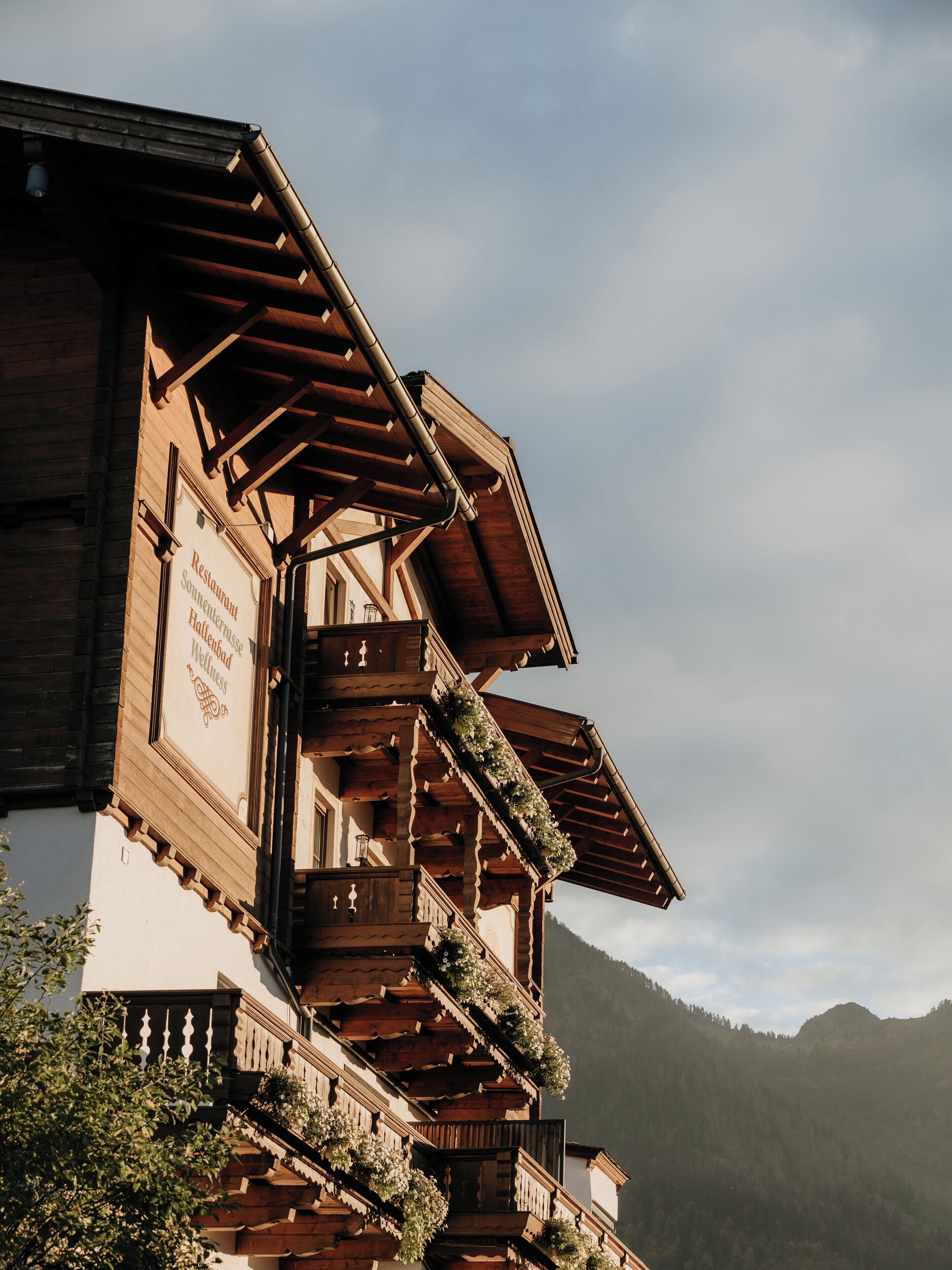 Un bâtiment traditionnel en bois, doté de nombreux balcons, dont certains sont ornés de plantes.