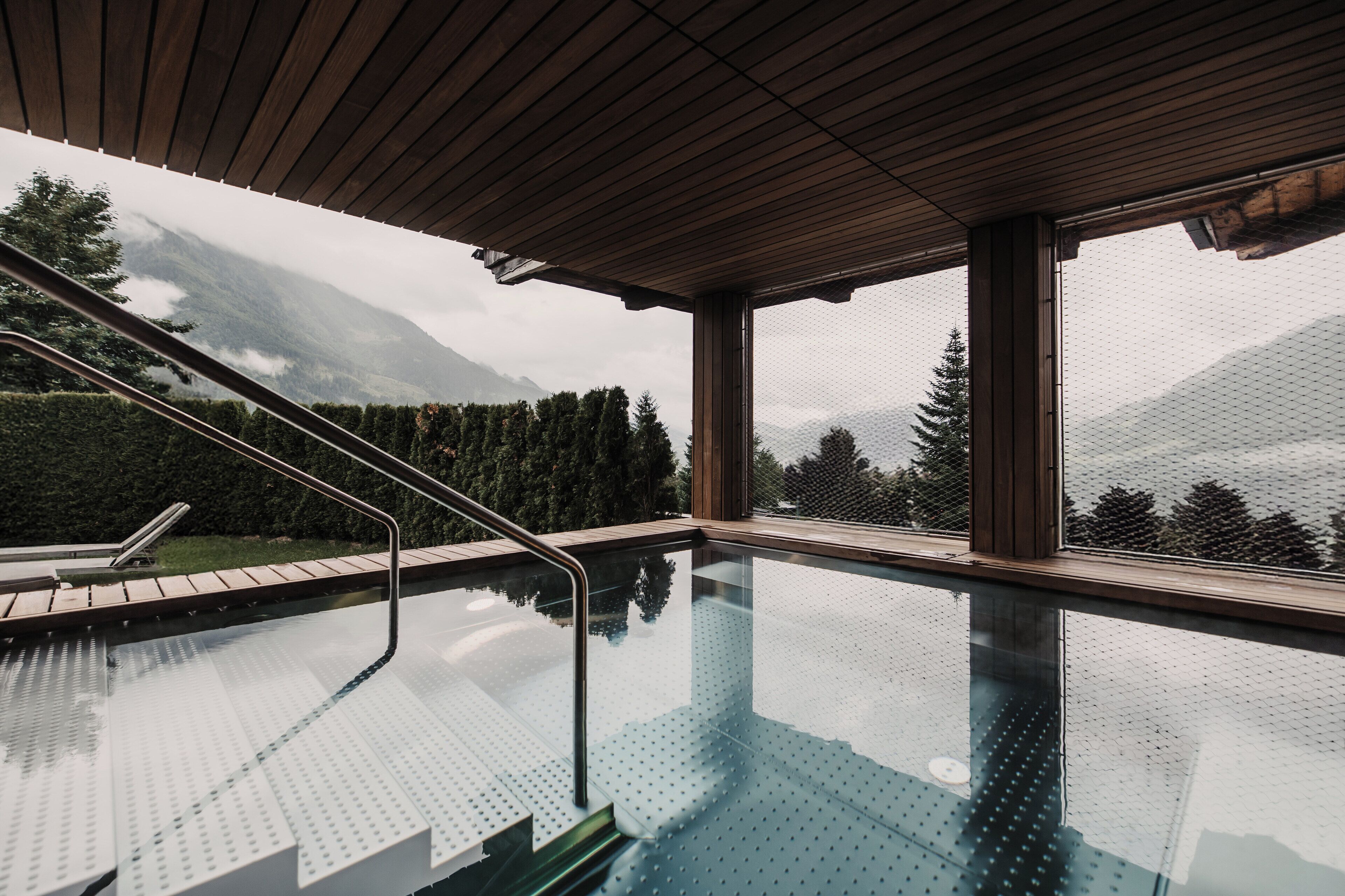Ein Hallenbad mit Blick auf Berge und Bäume.