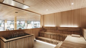 A modern sauna with wooden benches and a large window.