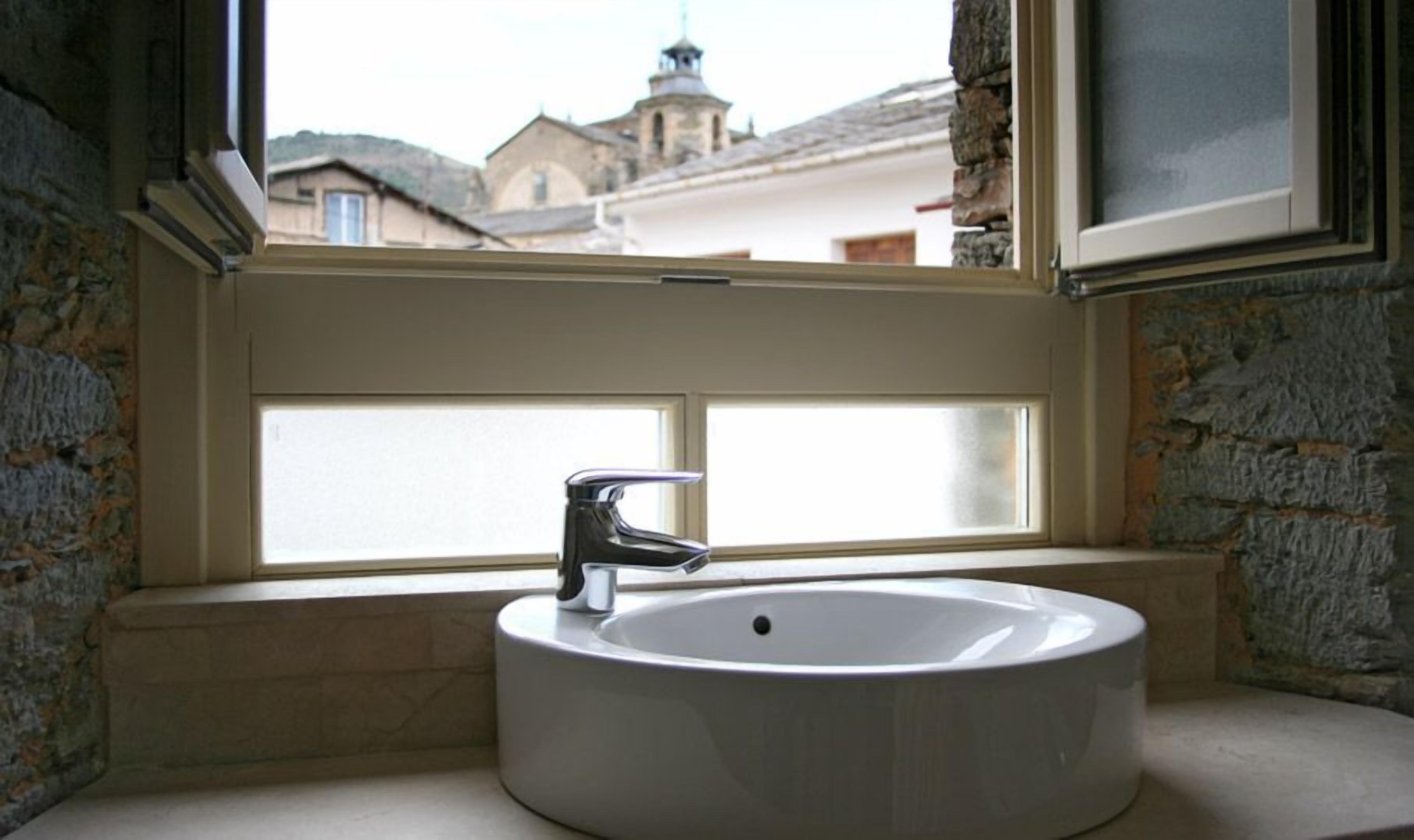 A bathroom with a white sink and a window.