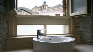 A bathroom with a white sink and a window.