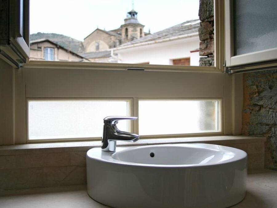 Un baño con lavabo blanco y ventana.