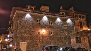Un edificio de piedra con varias ventanas y un cartel que indica un límite de velocidad de 10 km/h.