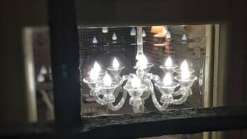 Uma janela com um candelabro visível através do vidro.
