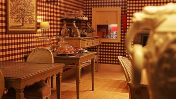 A dining area with a checkered wall, a table with chairs, and a lamp.