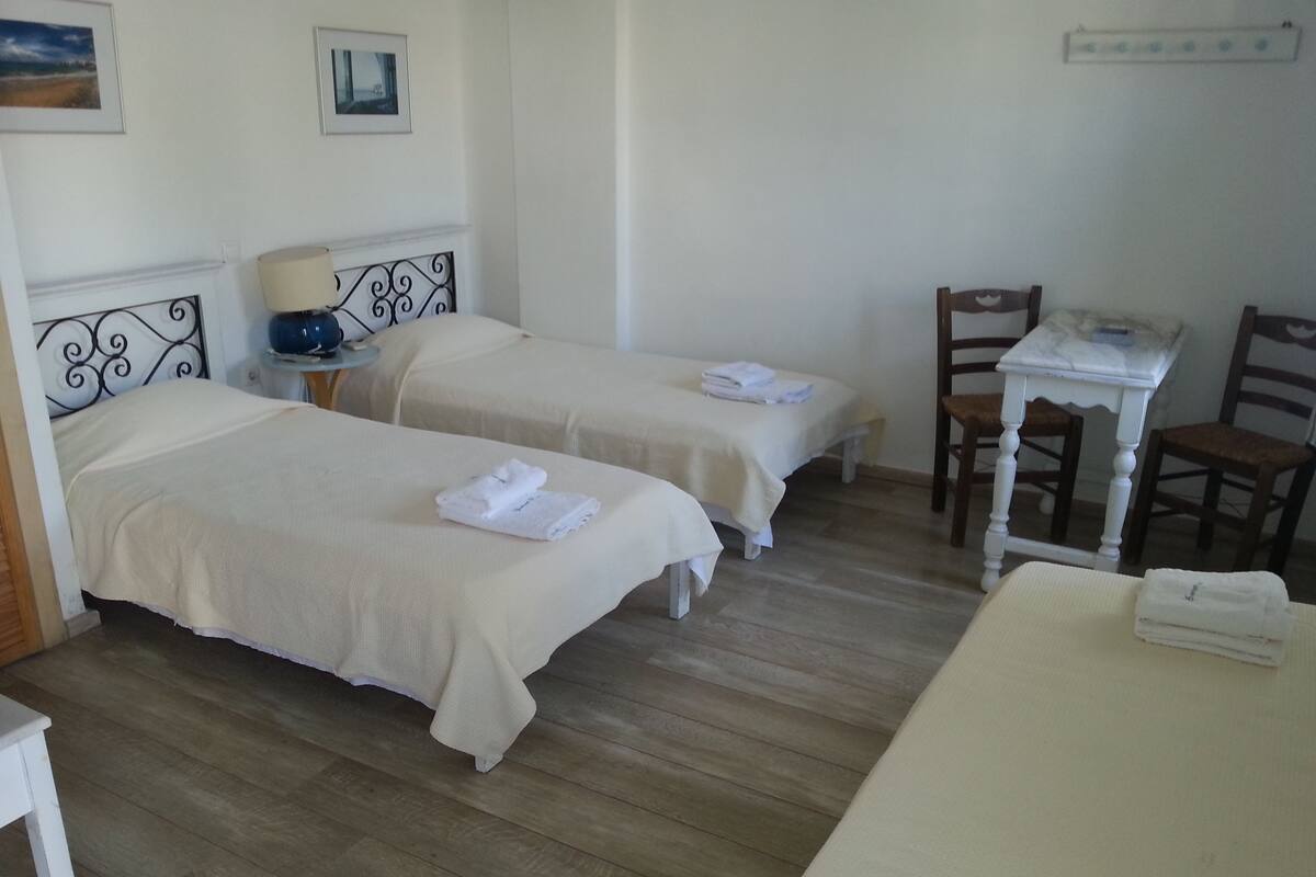 A room with two beds, a desk, and a chair.
