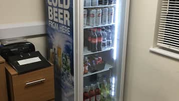 Una máquina expendedora con un letrero que anuncia 'Consigue una cerveza bien fría aquí'.