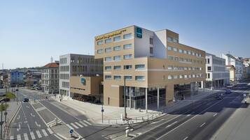 A modern hotel with a prominent Clarion Congress Hotel sign, multiple floors, and a glass facade.