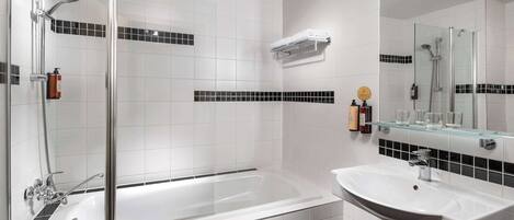 A modern bathroom with a glass-enclosed shower, a standalone bathtub, and a sink with a mirror above.