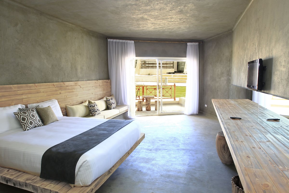 Ein Schlafzimmer mit einem Bett, einem Holzkopfende und einem Holztisch.
