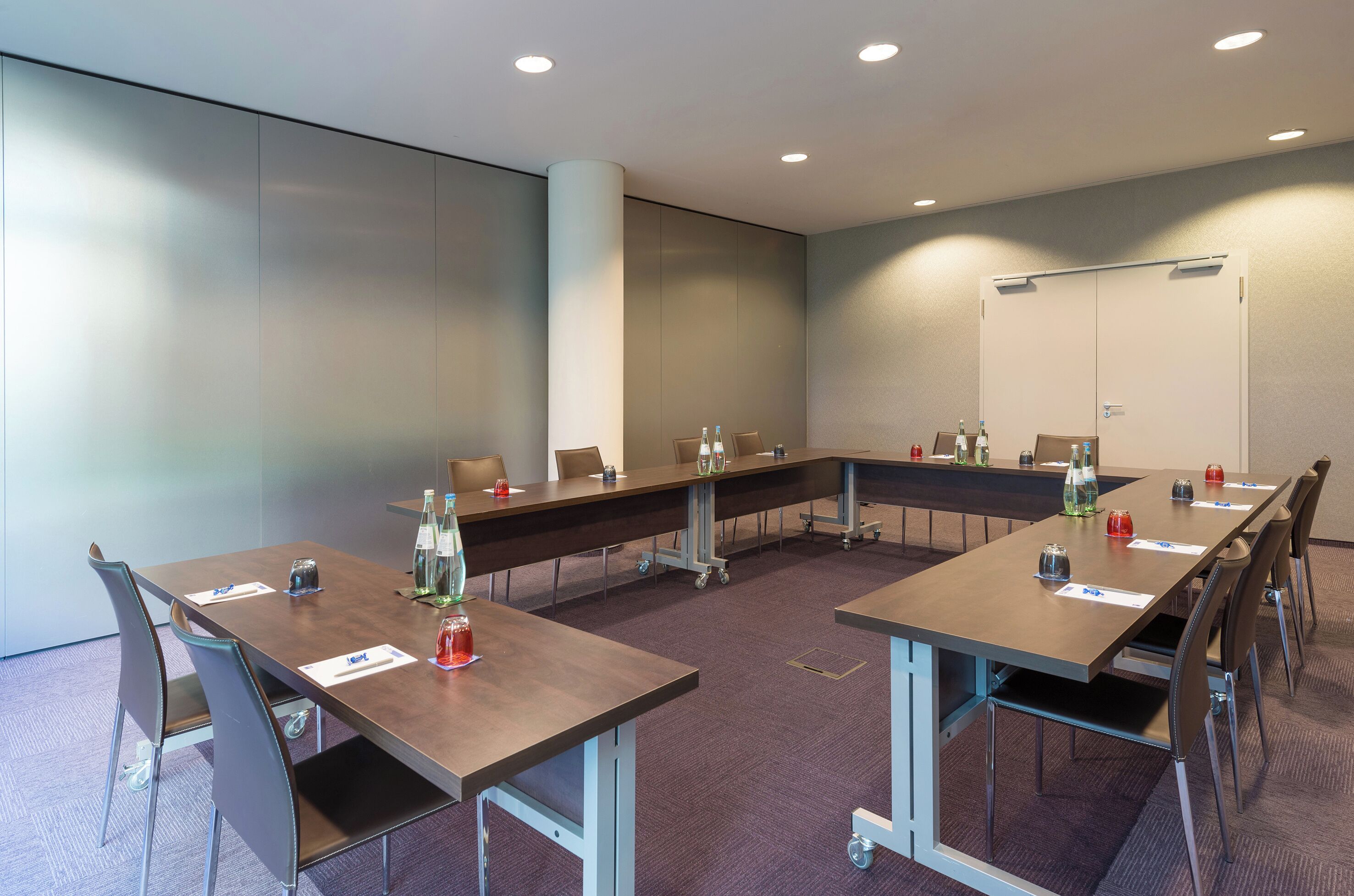 A conference room with a long table, chairs, and a whiteboard.