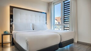 Ein modernes Schlafzimmer mit einem großen Bett, einem Nachttisch und einem Fenster mit Jalousien.
