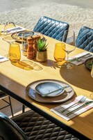 A table set for dining with a view of the beach.