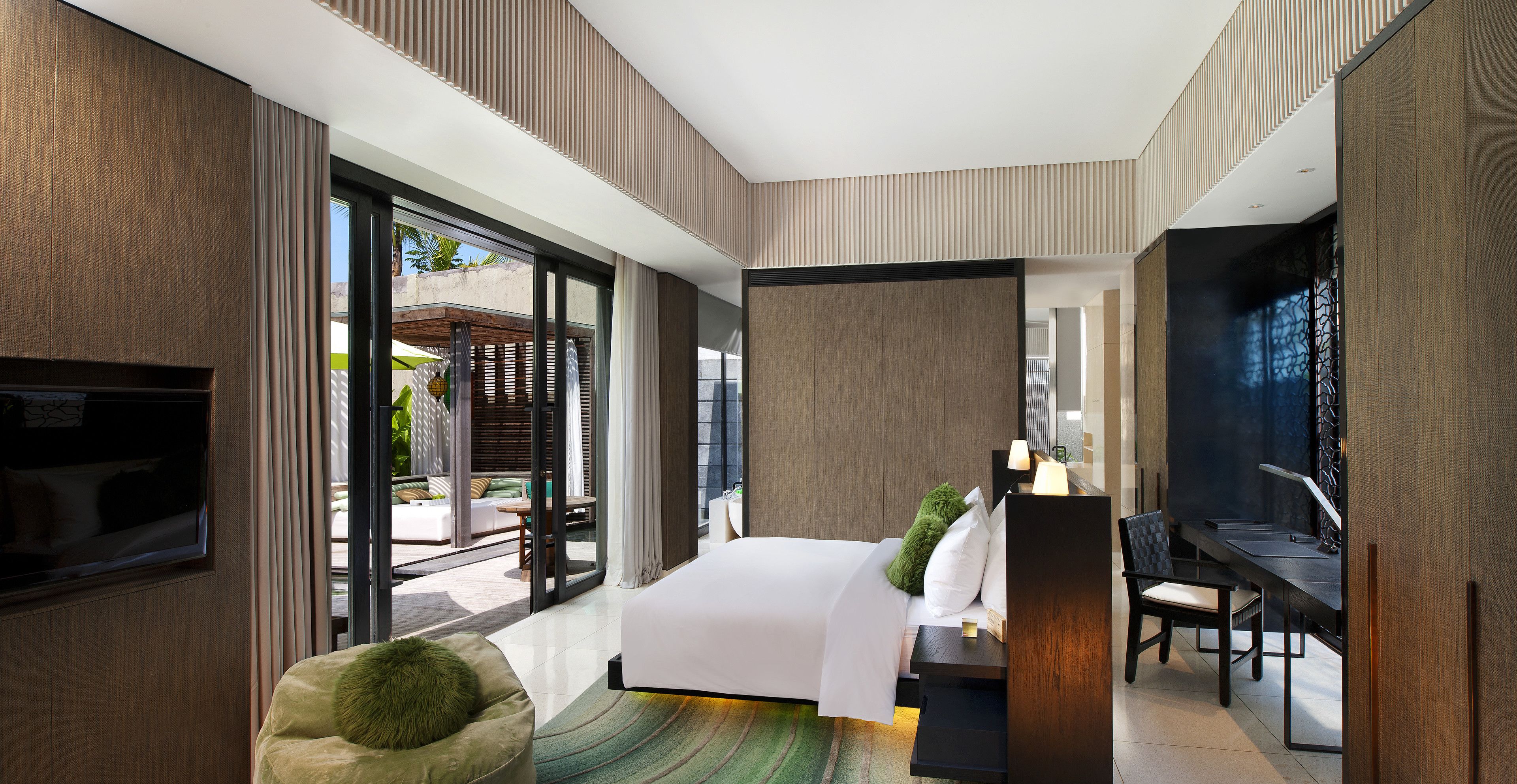 Una habitación de hotel moderna con una cama grande, un escritorio y una zona de estar.