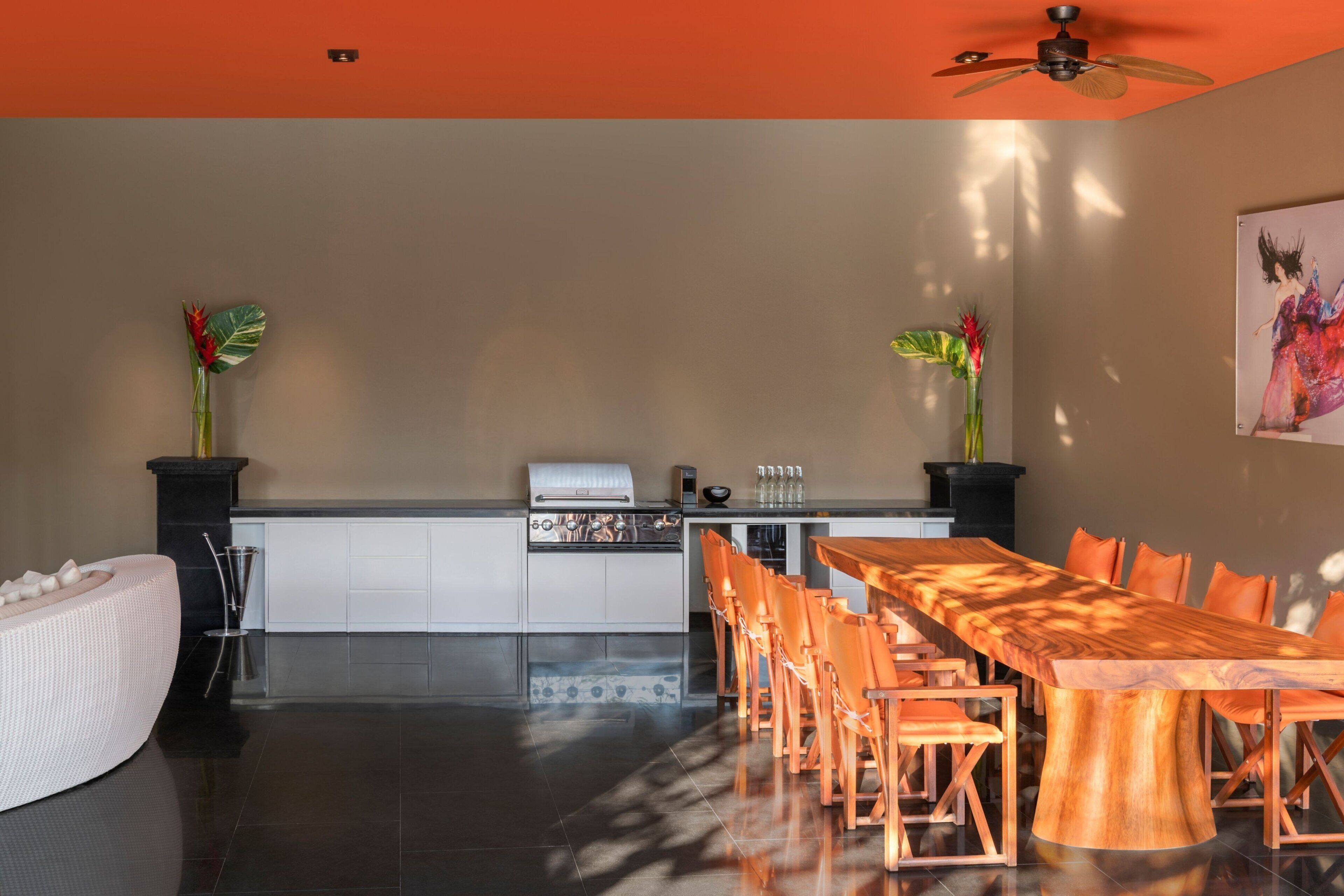 Una cocina moderna con horno integrado y comedor con mesa y sillas de madera.