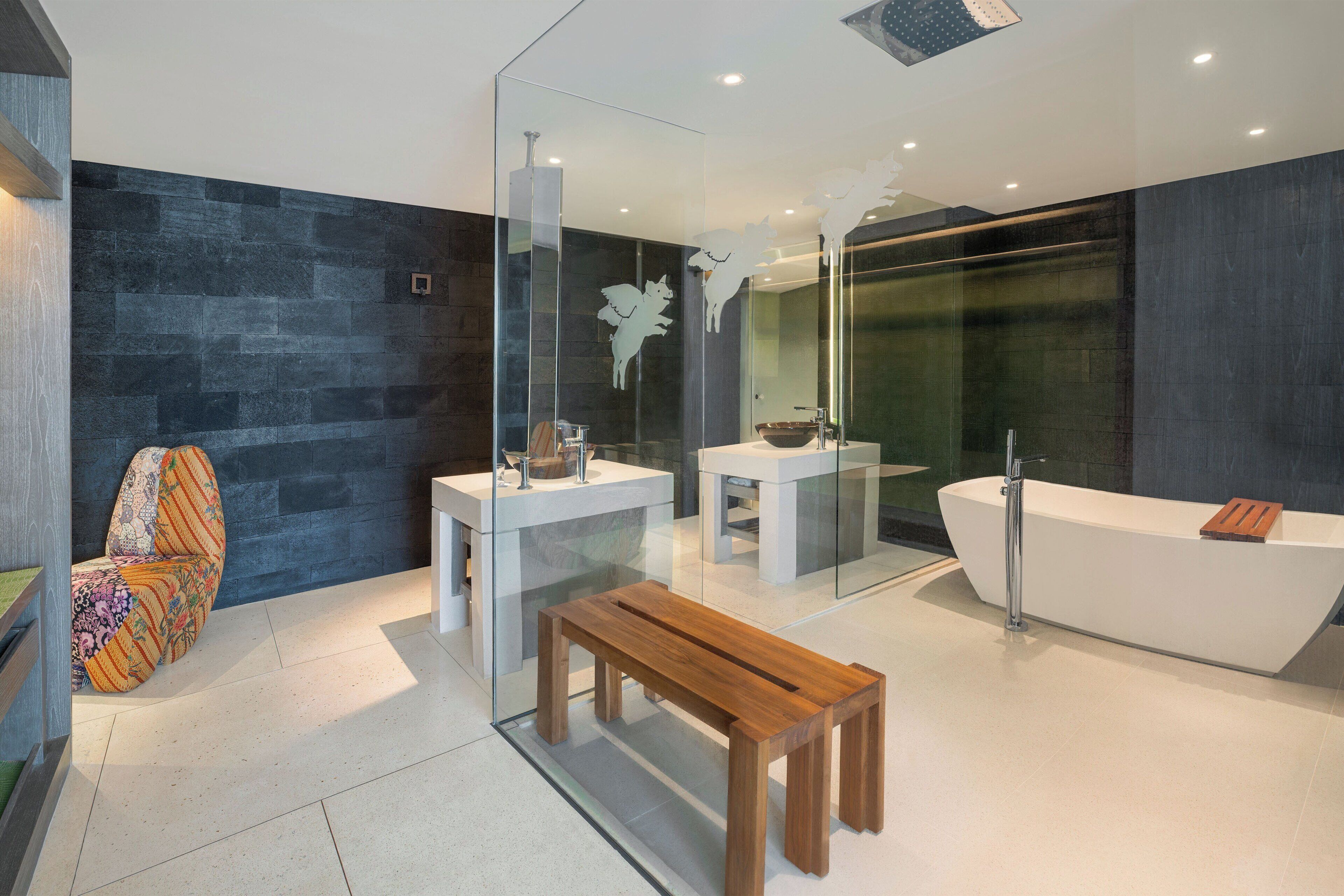 A modern bathroom with a freestanding bathtub, a glass-enclosed shower, and a wooden bench.