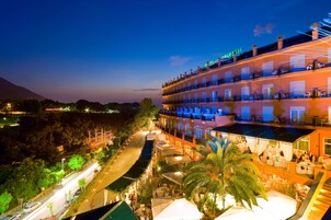 Un hotel con varios balcones, mobiliario exterior y vistas del paisaje circundante.
