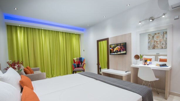 Quarto de hotel moderno com uma cama grande, uma escrivaninha e uma cadeira.