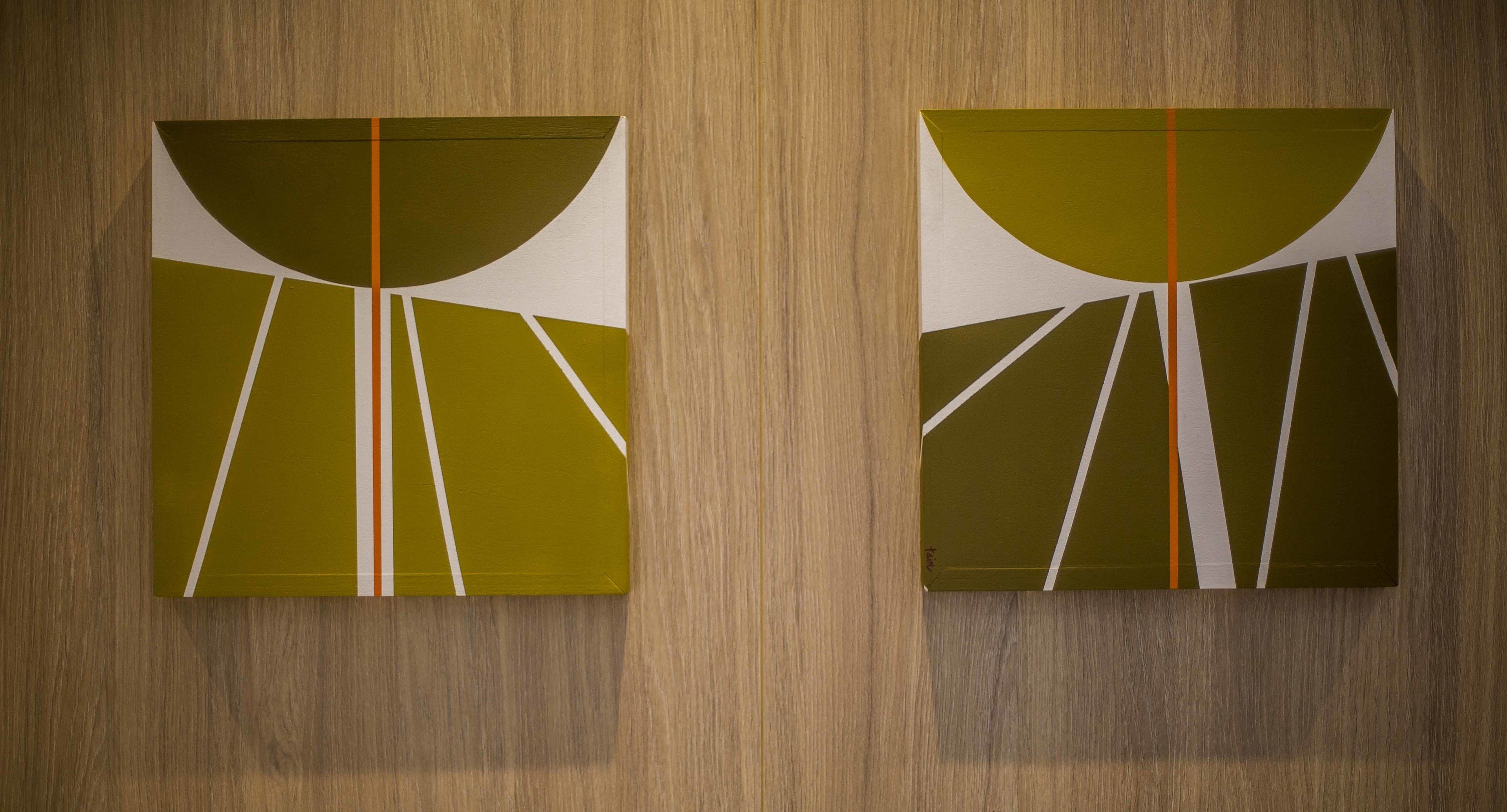 Two abstract paintings on a wooden wall.
