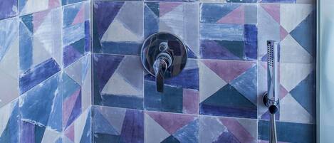 Ein Duschbereich mit einem geometrischen Fliesendesign.
