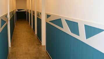 A long, narrow hallway with blue and white walls and a wooden floor.