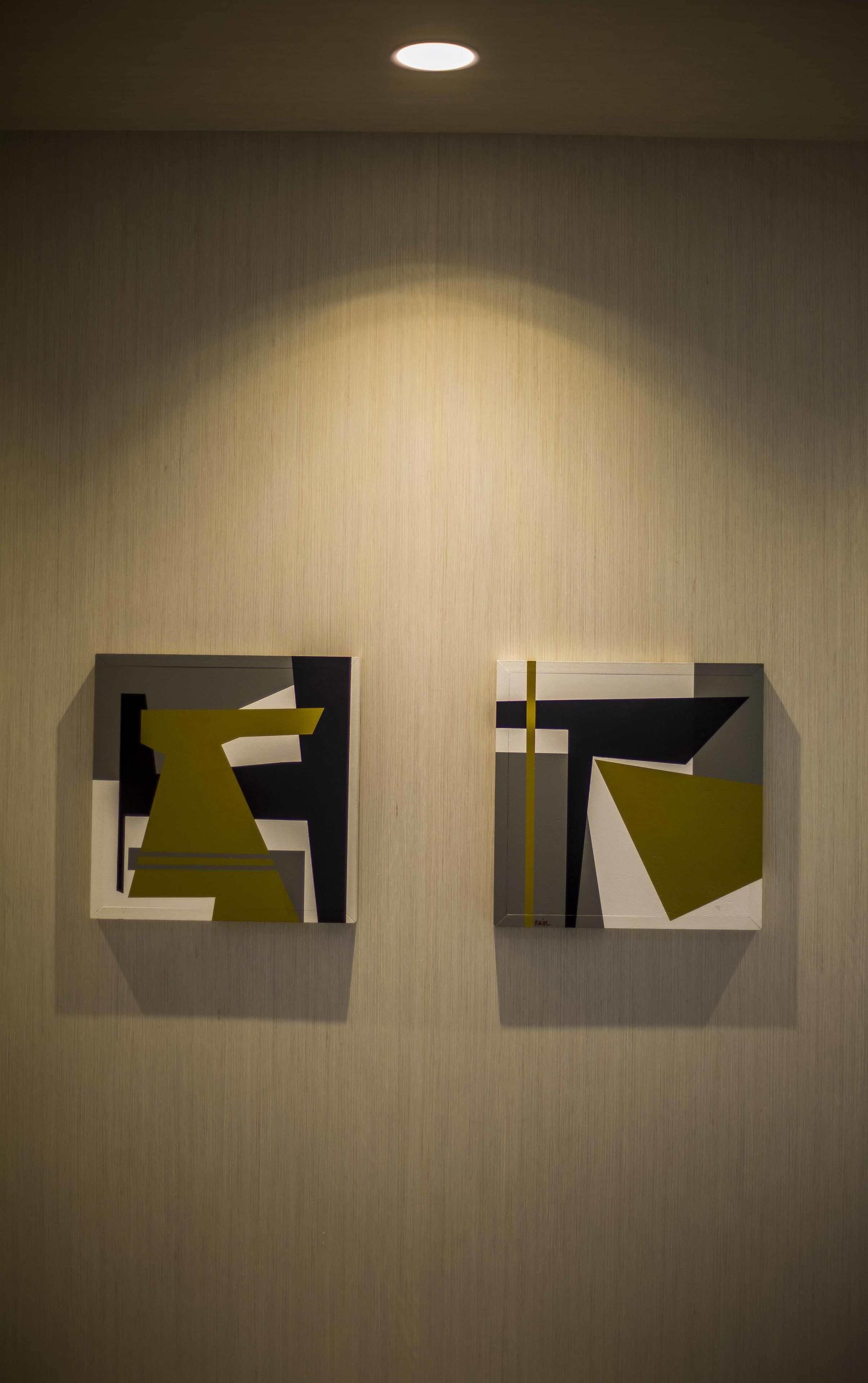 Deux peintures abstraites sur un mur à la texture particulière.